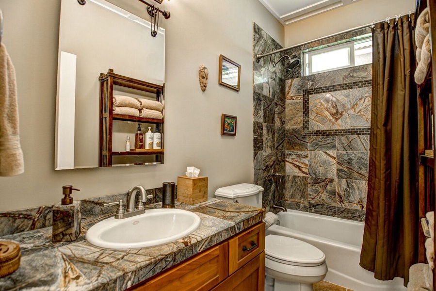 Bathroom 3 is shared with two bedrooms and has a full tub with shower and elegant marble tile
