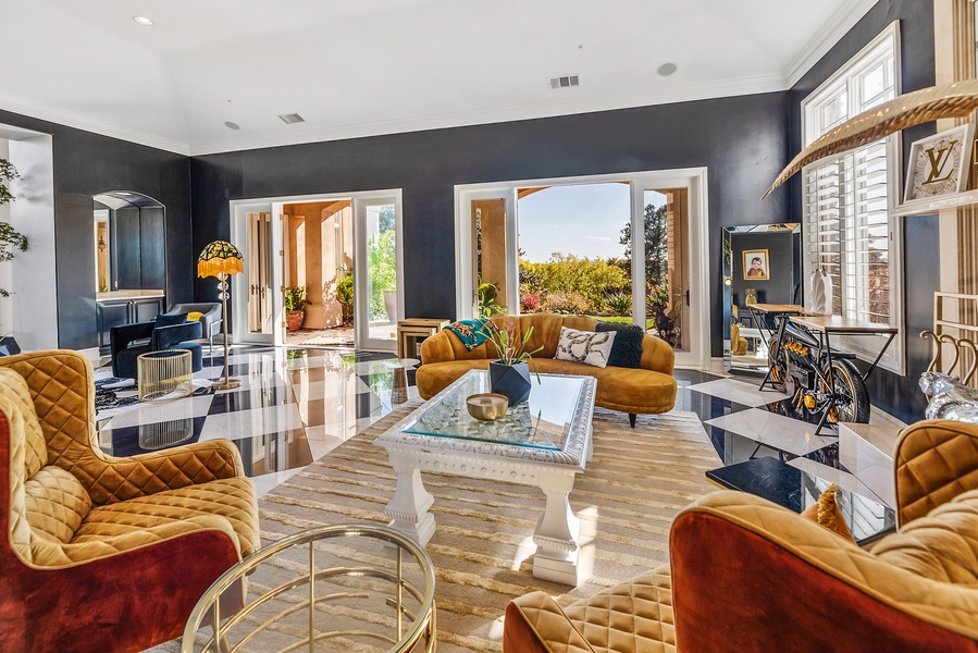 The "Grand Gatsby" with luxurious decor and flooring in dark grays, blues and oranges, floor to ceiling windows, French doors leading to the amazing back yard, stone fireplace and lots of natural light.