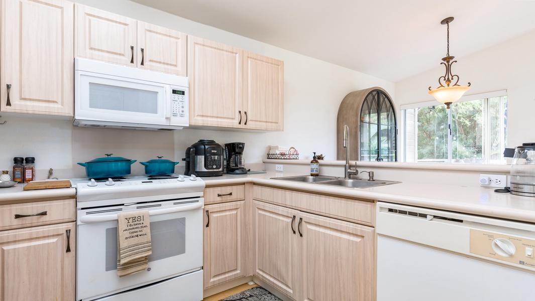 The bright kitchen features many amenities including a fridge, oven, extended counter-tops and high ceilings.