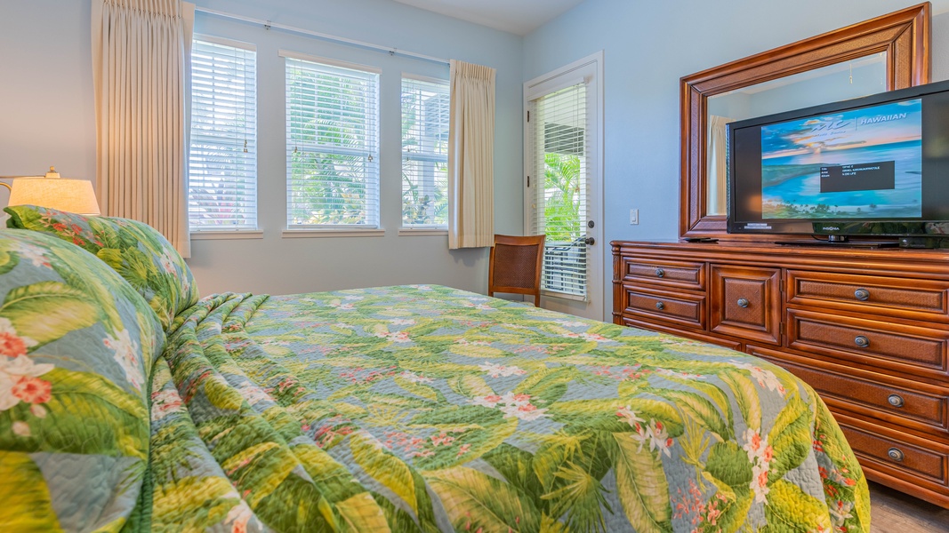The primary guest bedroom with floral prints and a large dresser.