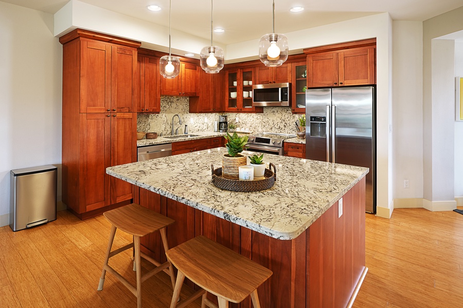 The kitchen is fully equipped with stainless steel appliances and breakfast bar seating.