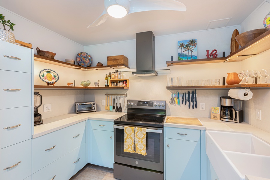 Open shelving, coastal touches, and an electric range make this kitchen both stylish and functional.