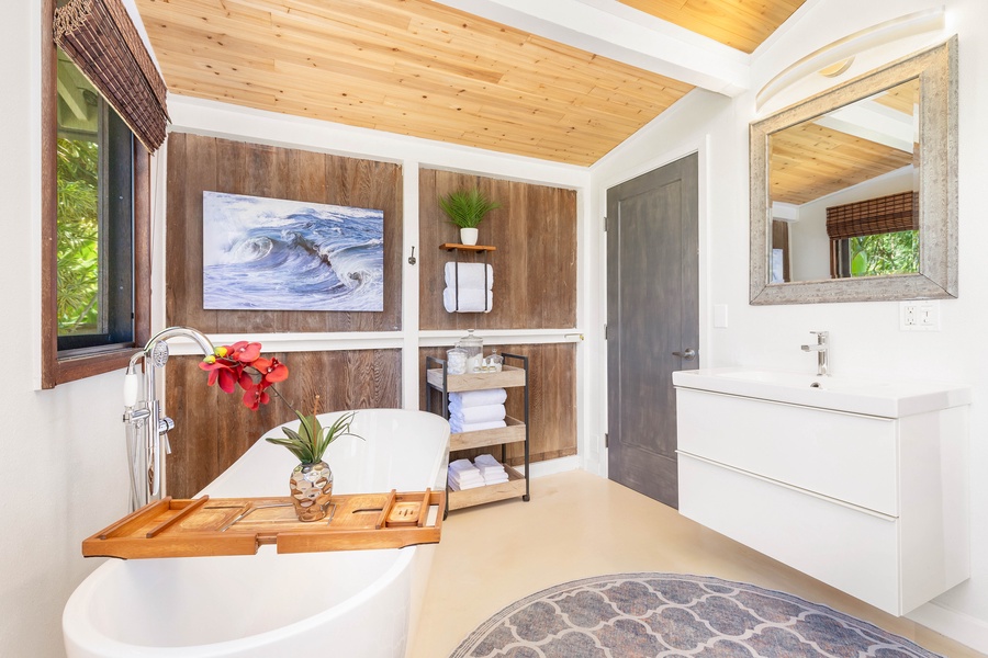 This serene bathroom features a walk-in shower, double vanity, and calming island-inspired decor.