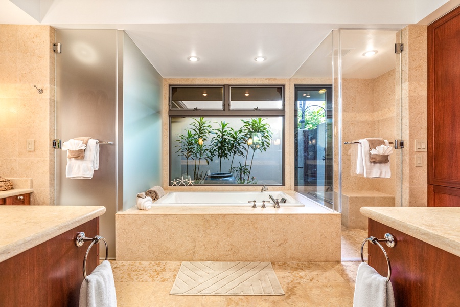 Detail of soaking tub overlooking tropical outdoor shower garden.