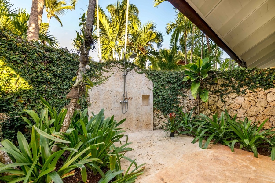Charming outdoor shower surrounded by lush greenery.