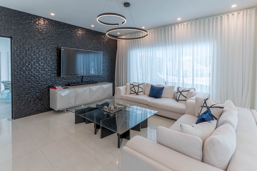 The living area has plush furnishings and large TV, perfect for unwinding.