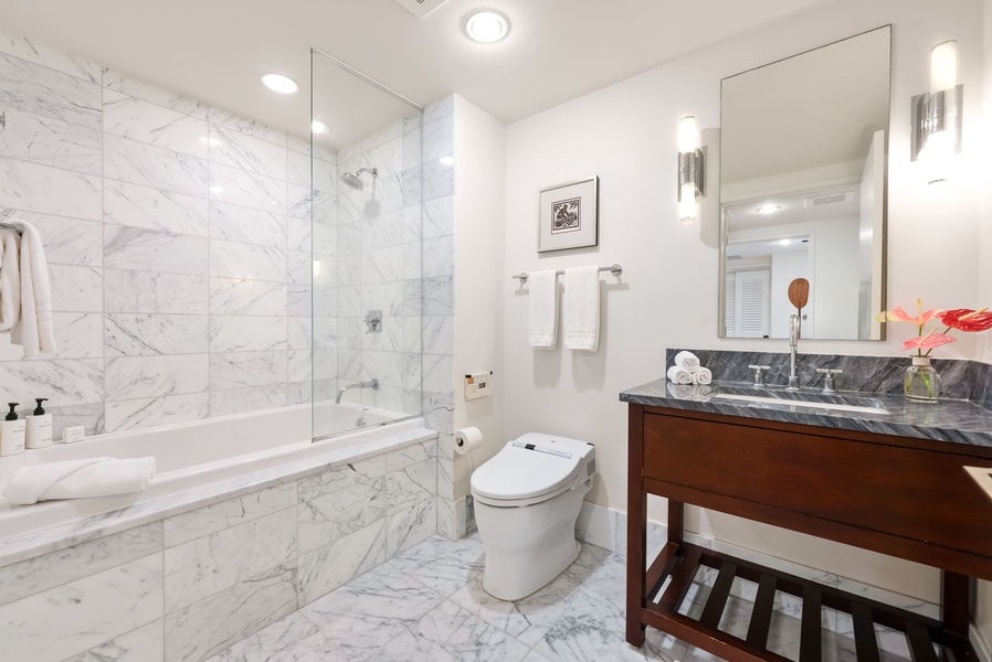 Modern 3rd guest bathroom featuring sleek marble finishes, a soaking tub, and elegant vanity.