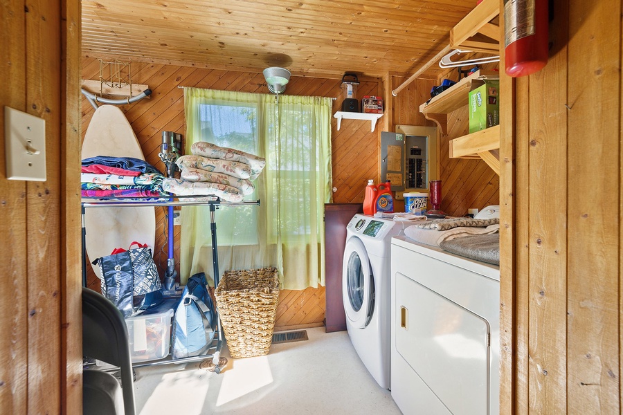 Your dedicated laundry space keeps your vacation wardrobe fresh with full washer and dryer access in this cozy wood-lined utility room.