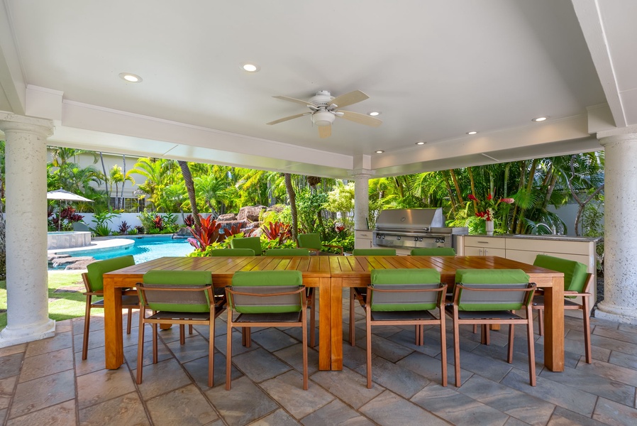 Outdoor dining space with a BBQ grill and ample seating, perfect for enjoying alfresco meals in a tropical setting.