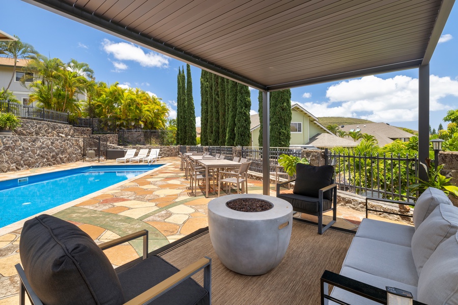 A built-in firepit and sectional seating make this poolside spot a go-to hangout for cozy evenings or casual entertaining.