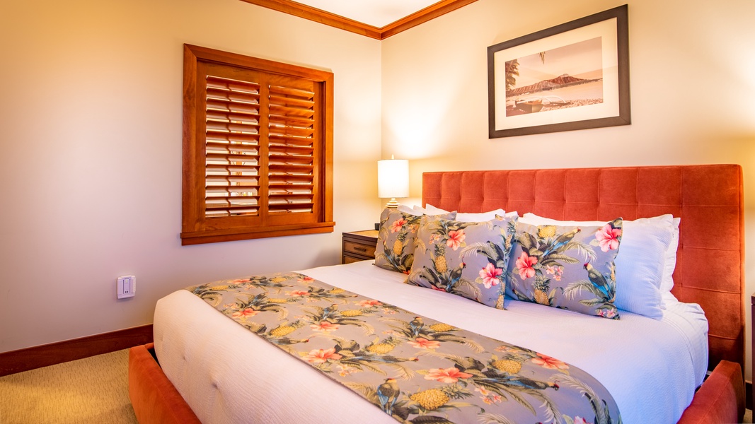 The primary guest bedroom with luxurious linens and bright patterns.