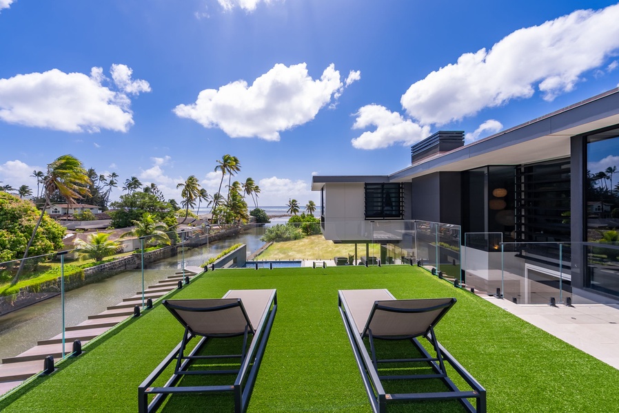 Lounge on the manicured lawn with open views toward the coastline.