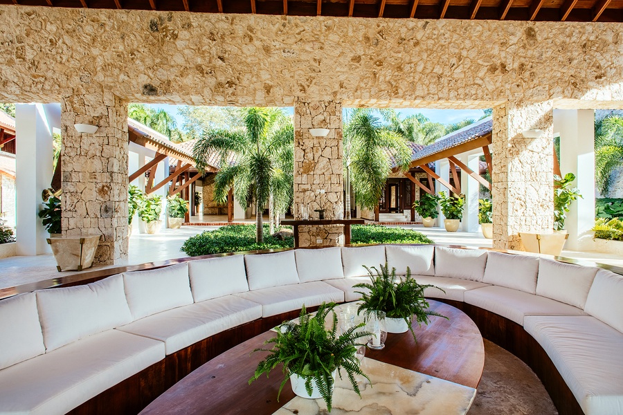 Open-air lounge area with comfortable seating and lush greenery.