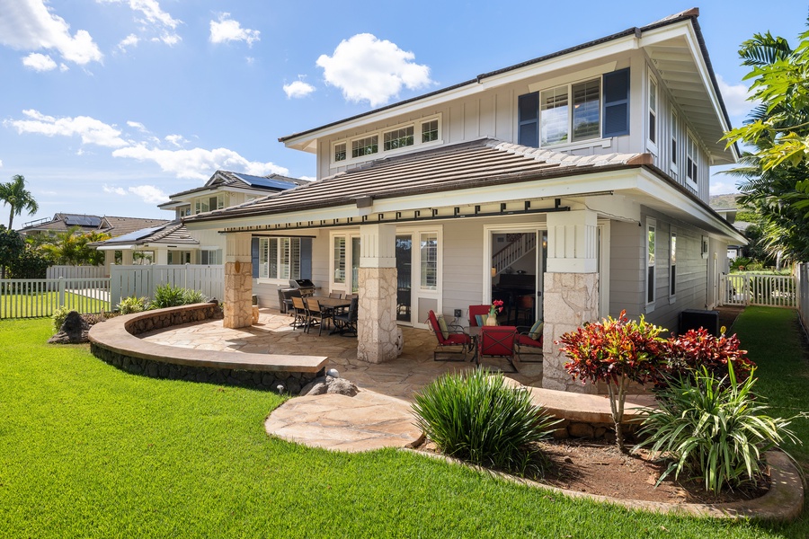 Beautiful two-story vacation home featuring covered lanai with outdoor dining and tropical landscaping in a peaceful residential setting.
