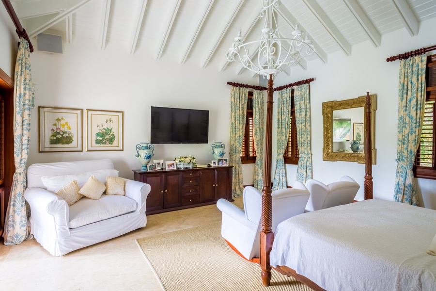 The primary suite features four-poster king bed with TV and lounge area.