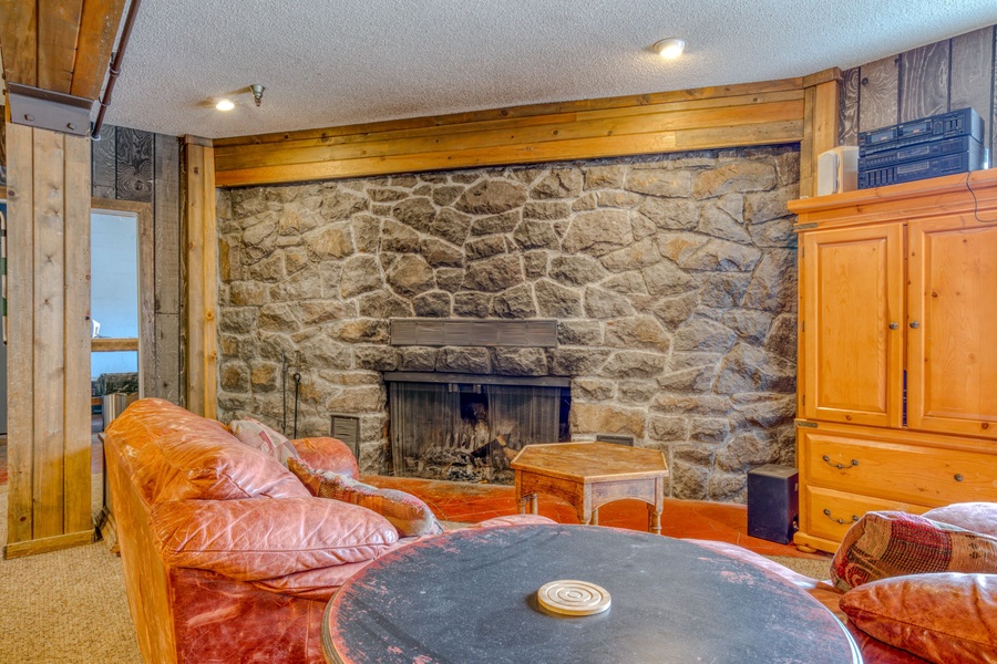 A cozy recreational room is located on the first floor of the lodge, equipped with a grand stone fireplace, foosball, and a pool table for endless hours of entertainment for the whole family