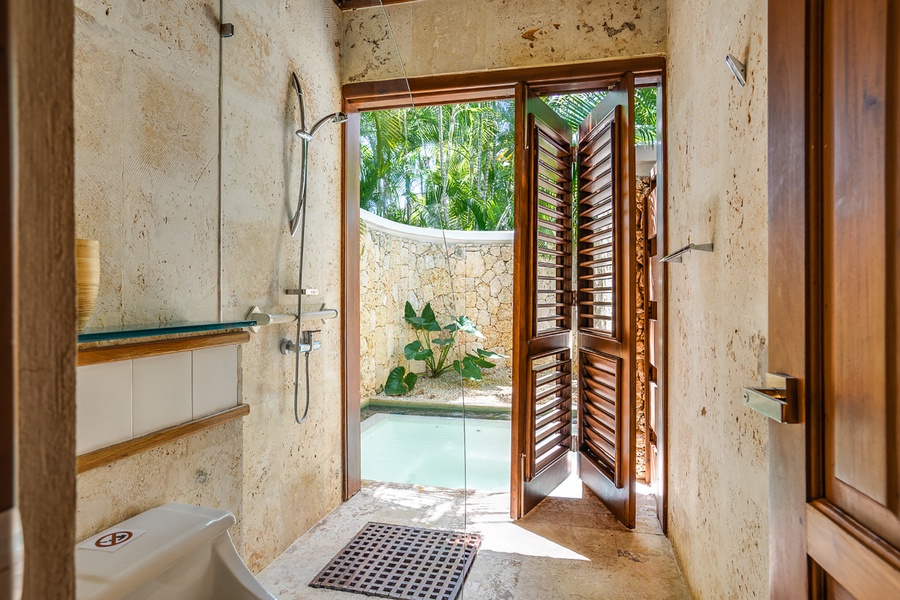 The ensuite bathroom features a garden shower, blending seamlessly with the natural surroundings.
