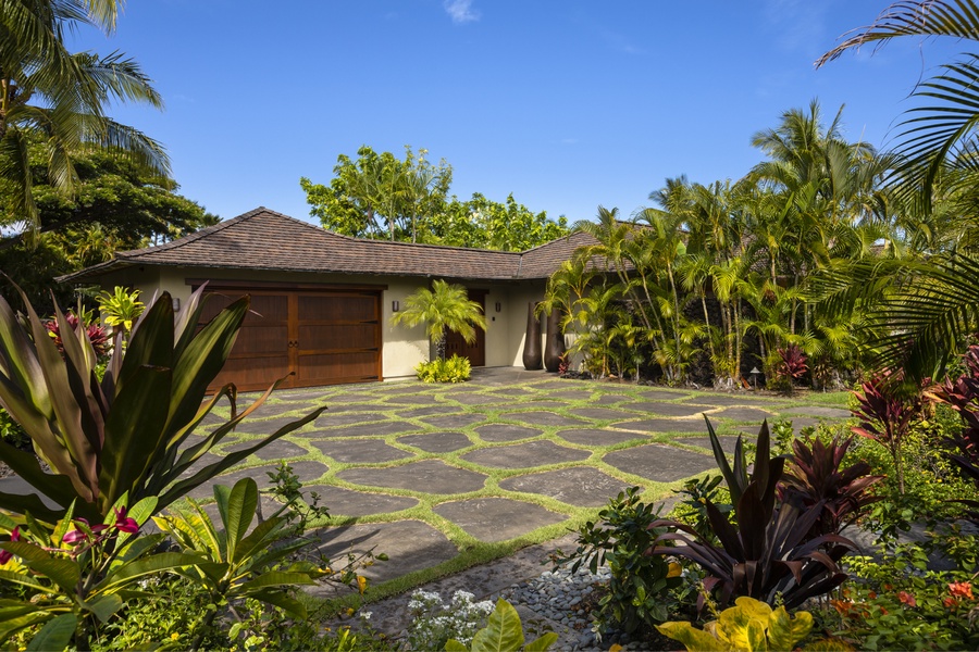 Driveway surrounded by luscious landscaping, offering privacy & ample parking