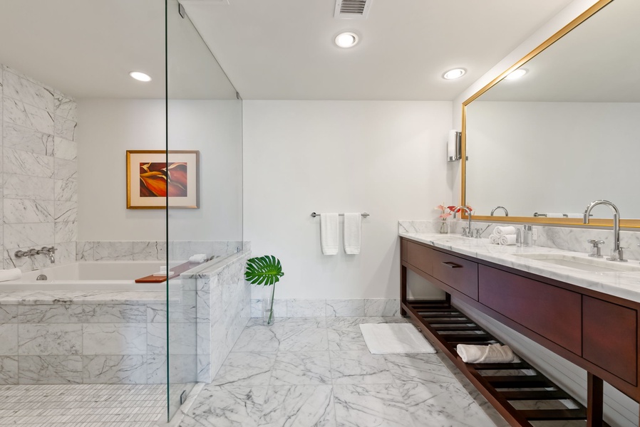 Luxurious marble primary bathroom with a spacious shower and deep soaking tub for ultimate relaxation.