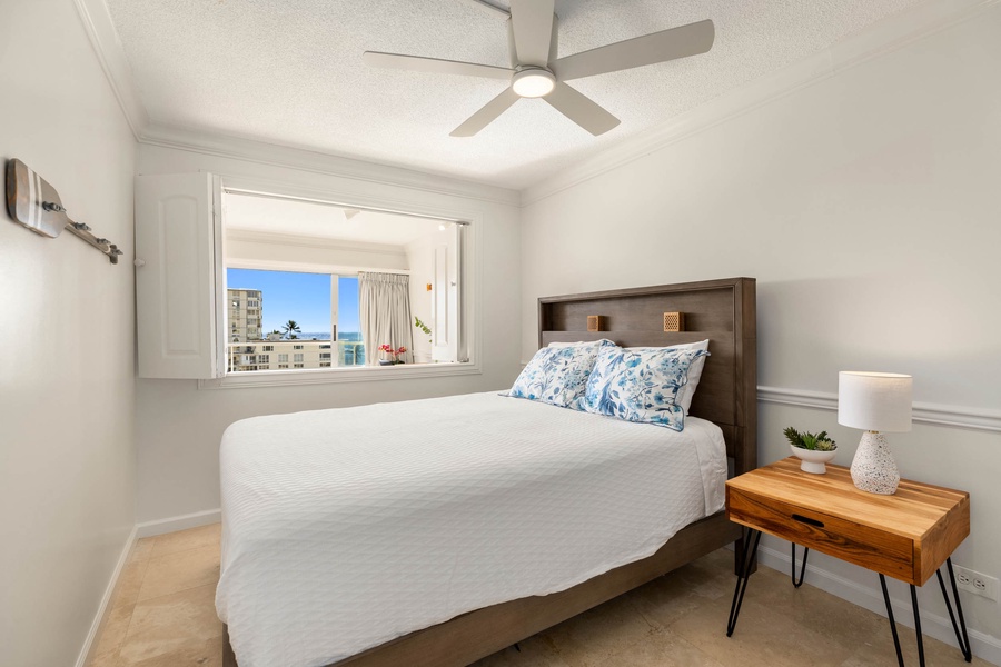 Cozy primary bedroom with plush bedding and scenic city views, designed for restful nights.