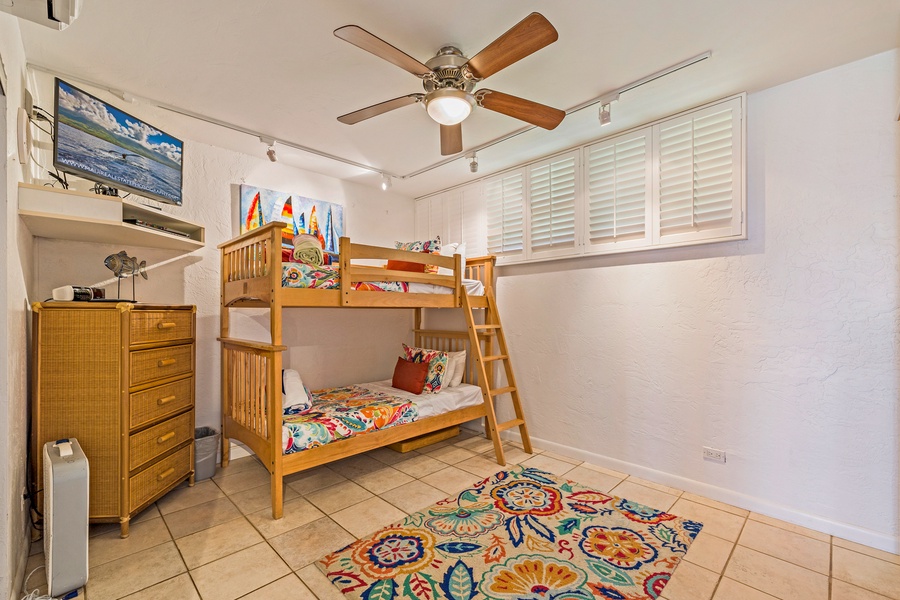 This charming bunk room is full of color and comfort, making it an ideal spot for kids or guests to relax after a day of fun