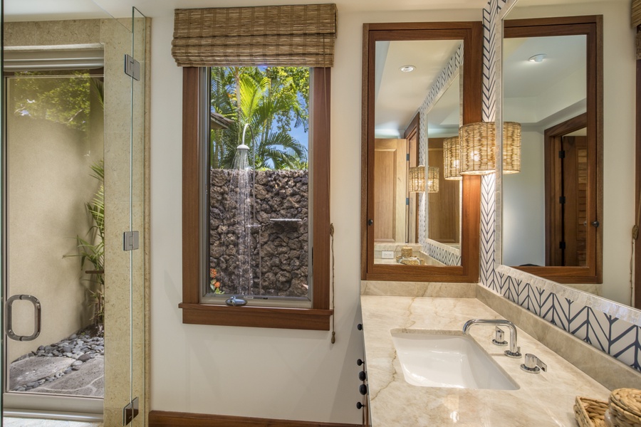 The en suite bath includes a glass-enclosed shower & an exterior garden shower