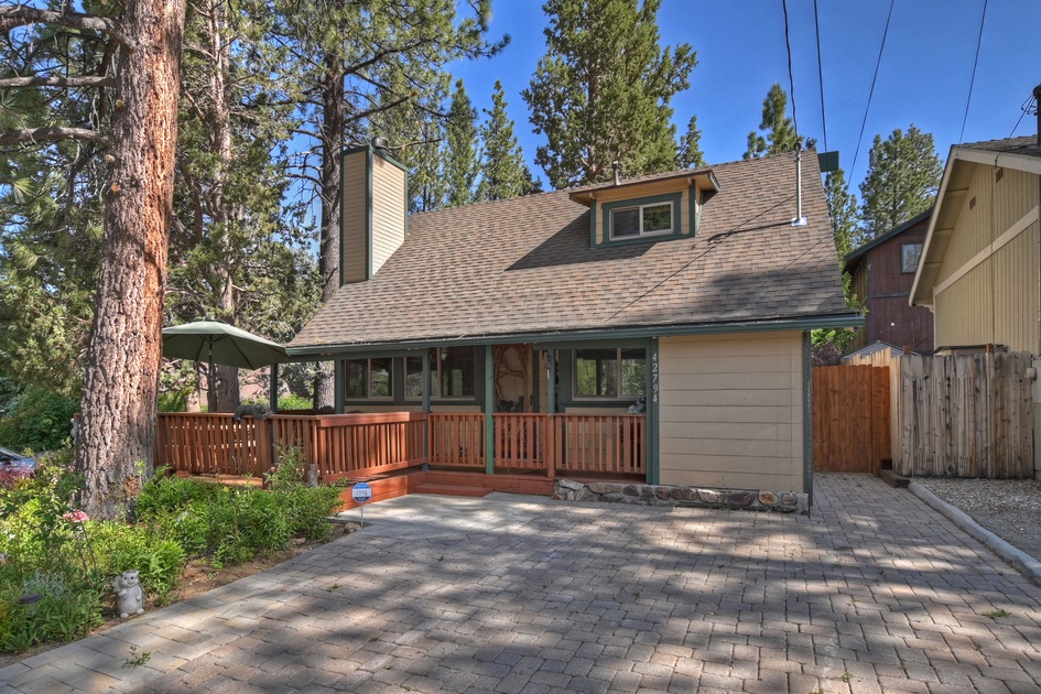 Premium Photo  A cozy modern home with a rustic touch featuring a large  stone fireplace and a wraparound porch