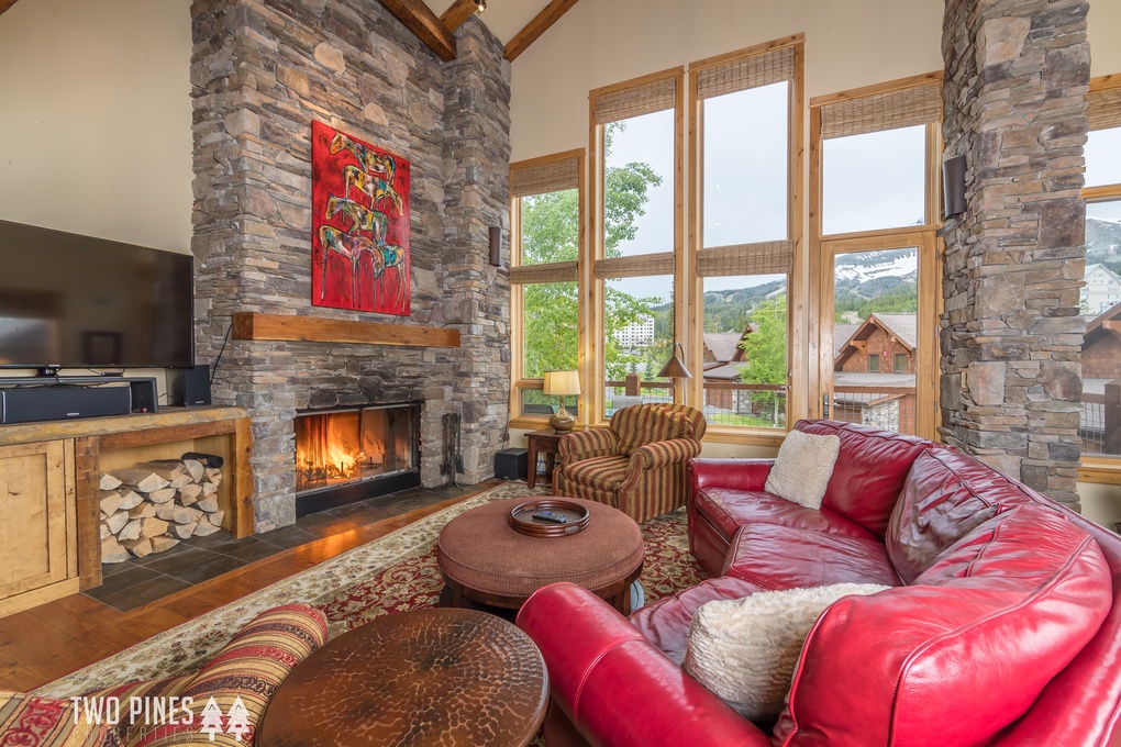 Grand living room with TV, wood burning fireplace, amazing views