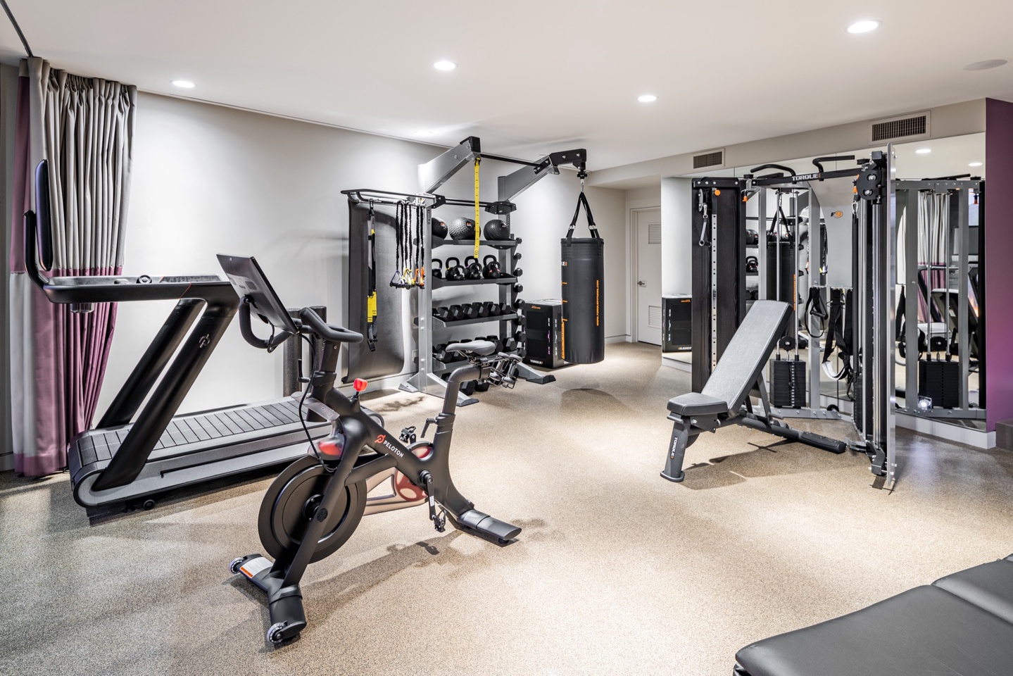 Spacious gym area w/ dumbbells, pulley, and more
