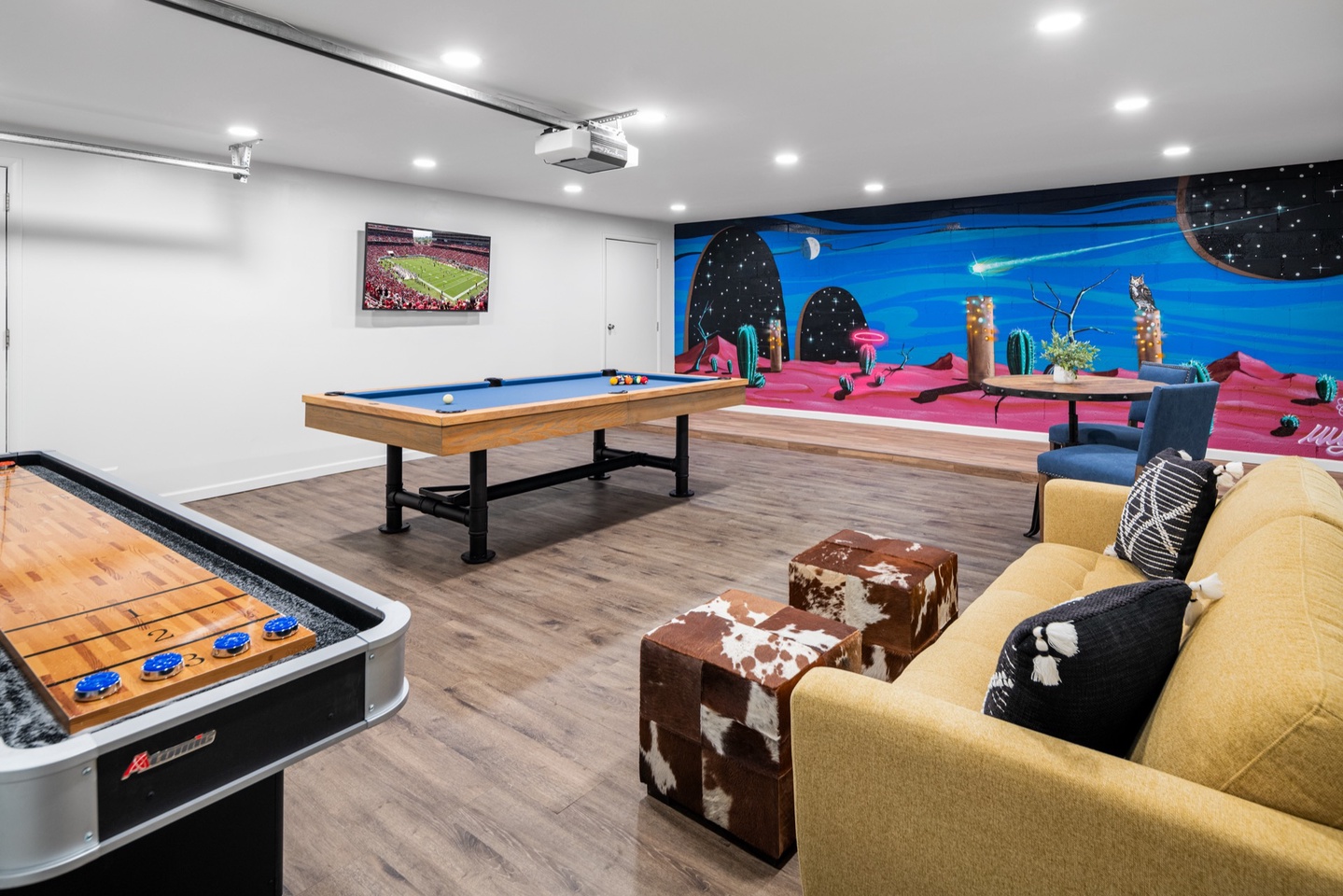 Pool table, shuffle board, wall TV, seating, and custom art backdrop